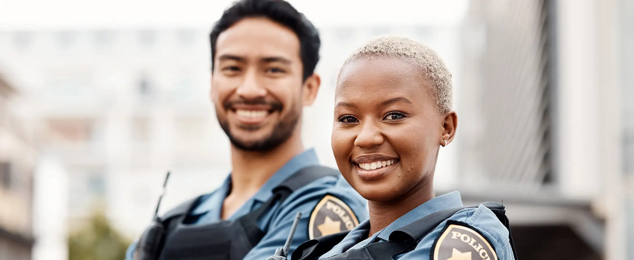 Two law enforcement officers in uniform smiling